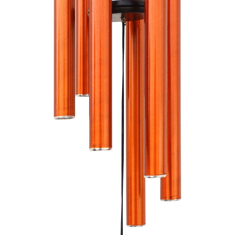 May include: Close-up of a wind chime with six orange-colored cylindrical tubes hanging from a black circular top. The tubes have silver-colored bottoms and are suspended by a black string. The background is white.