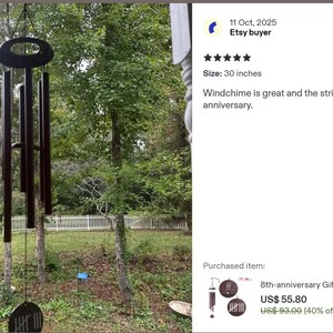 May include: A dark brown wind chime with five cylindrical tubes hanging from an oval-shaped top piece. The wind chime features a circular wind catcher at the bottom and is 30 inches in length as indicated by the product review text.