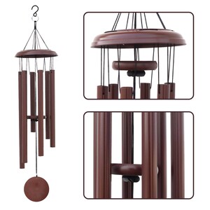 May include: A brown wind chime featuring six cylindrical tubes suspended from a circular top platform by black cords. A central wooden striker hangs above a circular wind catcher at the bottom, with a metal hook at the top for hanging.