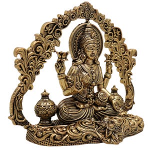 Op de afbeelding: Een gedetailleerd gouden beeld van een zittende godheid, versierd met ingewikkelde gravures en een halo. De figuur houdt lotusbloemen vast en wordt omlijst door een sierlijke boog. Twee decoratieve urnen flankeren de godheid, wat bijdraagt aan het uitgebreide ontwerp van het beeld.