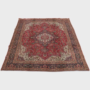 May include: A large, rectangular Persian rug with a central medallion design. The rug features a predominantly red field with intricate floral and geometric patterns in navy, cream, and brown. The border is a dark navy with floral motifs.