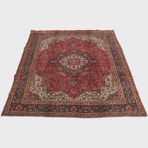 May include: A large, rectangular Persian rug with a central medallion design. The rug features a predominantly red field with intricate floral and geometric patterns in navy, cream, and brown. The border is a dark navy with floral motifs.
