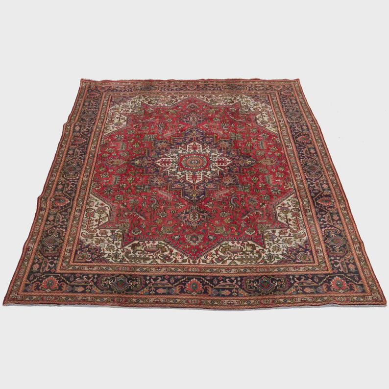 May include: A large, rectangular Persian rug with a central medallion design. The rug features a predominantly red field with intricate floral and geometric patterns in navy, cream, and brown. The border is a dark navy with floral motifs.