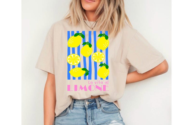Puede incluir: Camiseta beige con un gr&aacute;fico de lim&oacute;n. El dise&ntilde;o presenta limones amarillos con hojas verdes y rayas azules, con el texto "La vita al LIMONE" en rosa. La camiseta es de estilo casual.