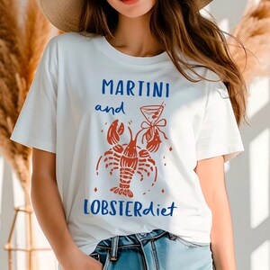 May include: White t-shirt with a red lobster and martini glass graphic and the text "Martini and Lobsterdiet".