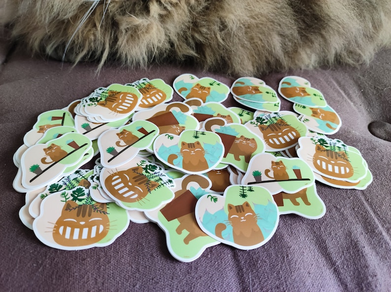 Pode incluir: Uma cole&ccedil;&atilde;o de adesivos coloridos com gatos de desenho animado com rostos sorridentes. Os gatos s&atilde;o retratados em v&aacute;rias poses, incluindo sentados em vasos de plantas, relaxando em prateleiras e relaxando em um fundo azul e verde. Os adesivos s&atilde;o perfeitos para adicionar um toque de fantasia a laptops, garrafas de &aacute;gua ou di&aacute;rios.