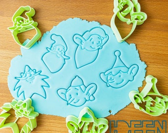 May include: Green plastic cookie cutters shaped like gnomes, elves, and a Christmas tree. The cutters are on a blue background with the words "Ideen Bäckerei" in green.
