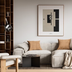 May include: A living room interior with a beige sectional sofa, two brown throw pillows, a black side table, a floor lamp, and a framed black and white abstract art print on the wall. The art print has the text "El Lissitzky, Proun 1923" below the image.