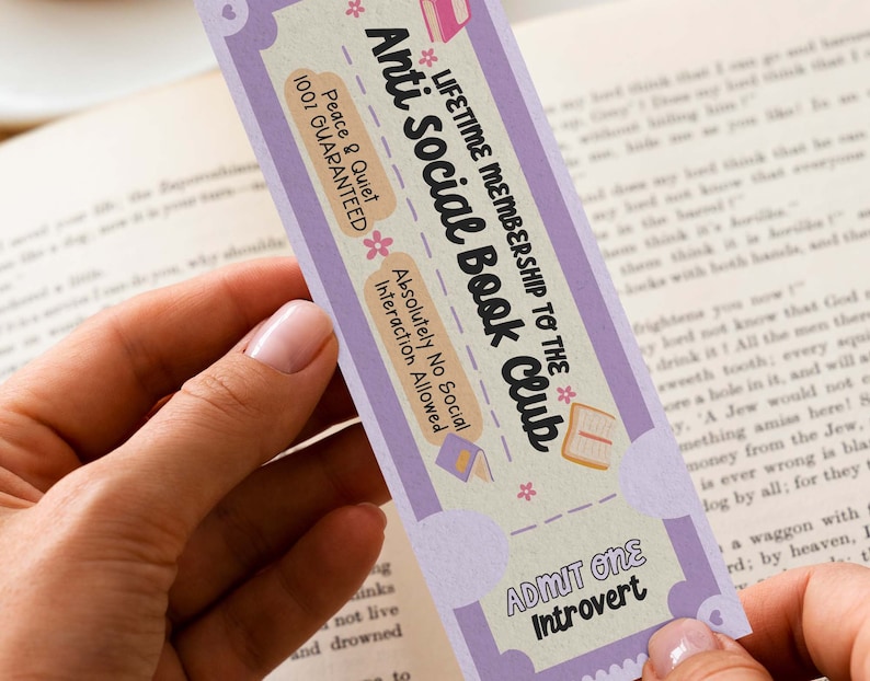 Puede incluir: Un marcap&aacute;ginas morado y blanco con el texto "Anti Social Book Club" y "Membres&iacute;a de por vida" en una fuente caprichosa. Tambi&eacute;n dice "Peace & Quiet 100% Guaranteed" y "Absolutely No Social Interaction Allowed". El marcap&aacute;ginas tiene un coraz&oacute;n rosa en la parte superior e inferior y un dise&ntilde;o de flores rosas.