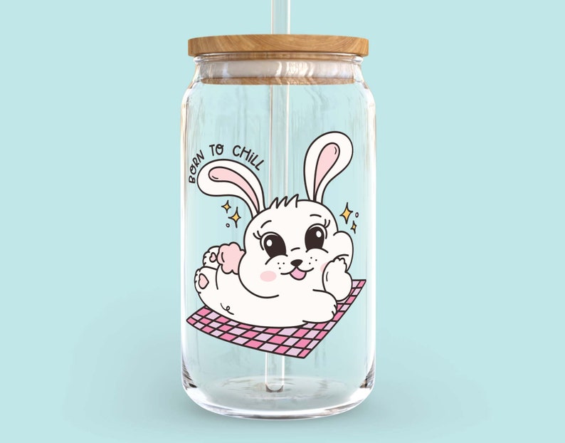 May include: A clear glass water bottle with a wooden lid and a straw. The bottle has a cartoon image of a white bunny with pink ears and the text "Born to Chill".