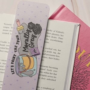 May include: Purple bookmark with a paint can, paintbrush, and a book with the text "Morally Grey" and the words "Let's Paint the Town".