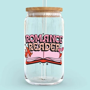 May include: A clear glass jar with a wooden lid and a straw. The jar has a pink and red graphic of a book with flames and hearts and the text "Romance Reader".