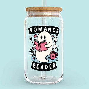 Op de afbeelding: Een glazen pot met een houten deksel en een rietje. De pot heeft een afbeelding van een geest die een boek leest met de tekst "Romance Reader" en harten.