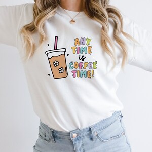 May include: White sweatshirt with a colorful graphic of a coffee cup and the text "ANY TIME is COFFEE TIME!"