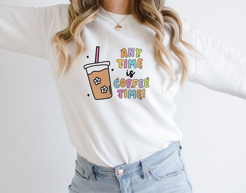 May include: White sweatshirt with a colorful graphic of a coffee cup and the text "ANY TIME is COFFEE TIME!"