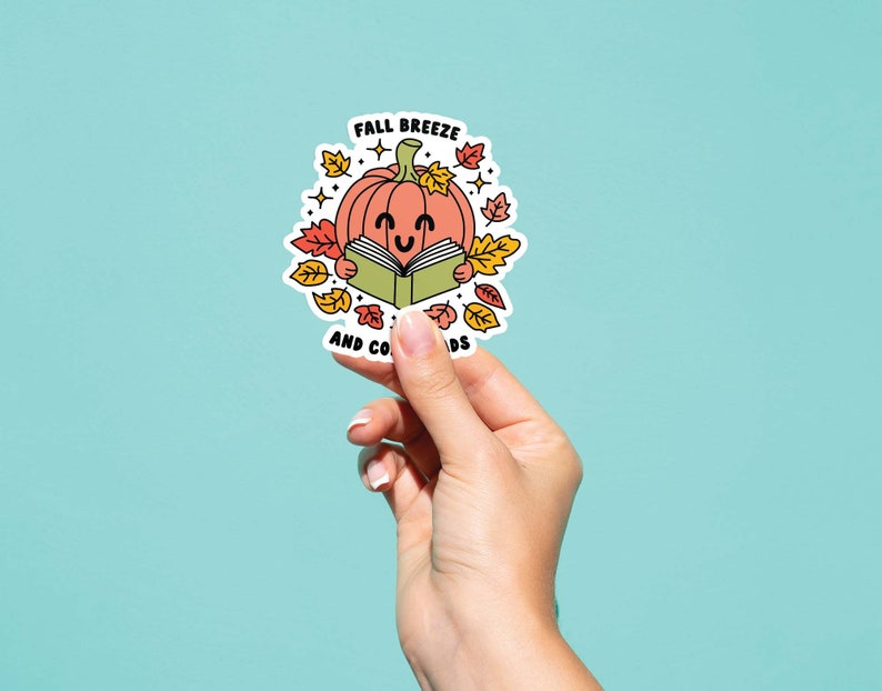 May include: A sticker with a cartoon pumpkin reading a book. The sticker says "Fall Breeze and Cozy Reads".