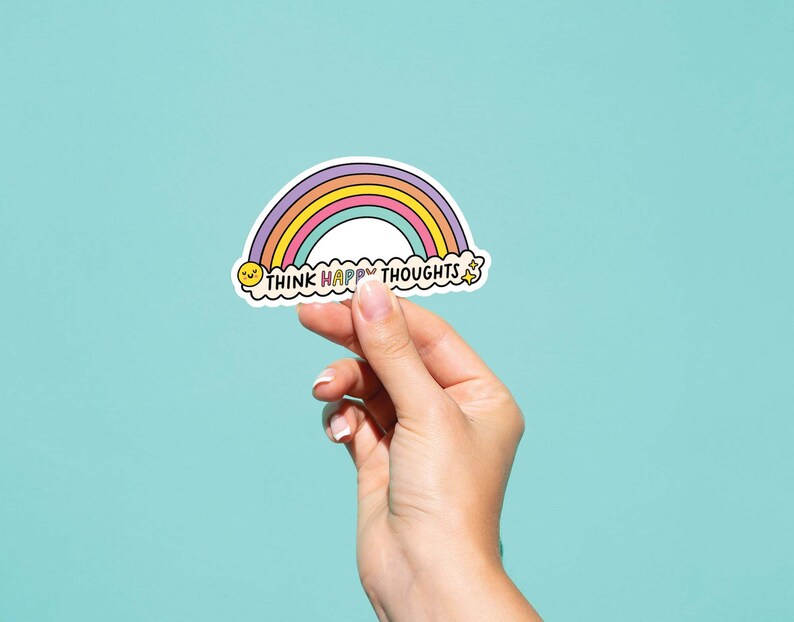 May include: A rainbow sticker with the text "Think Happy Thoughts" in a cloud shape. The rainbow is made of pink, orange, yellow, green, blue, and purple. There is a yellow smiley face in the cloud.