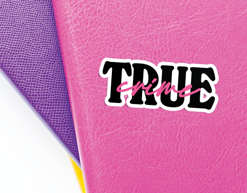May include: A pink leather notebook with a black and white sticker that says "TRUE crime" in pink lettering.