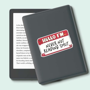 May include: A gray Kindle e-reader with a red and white sticker that says "Hello I'm Never Not Reading Smut".