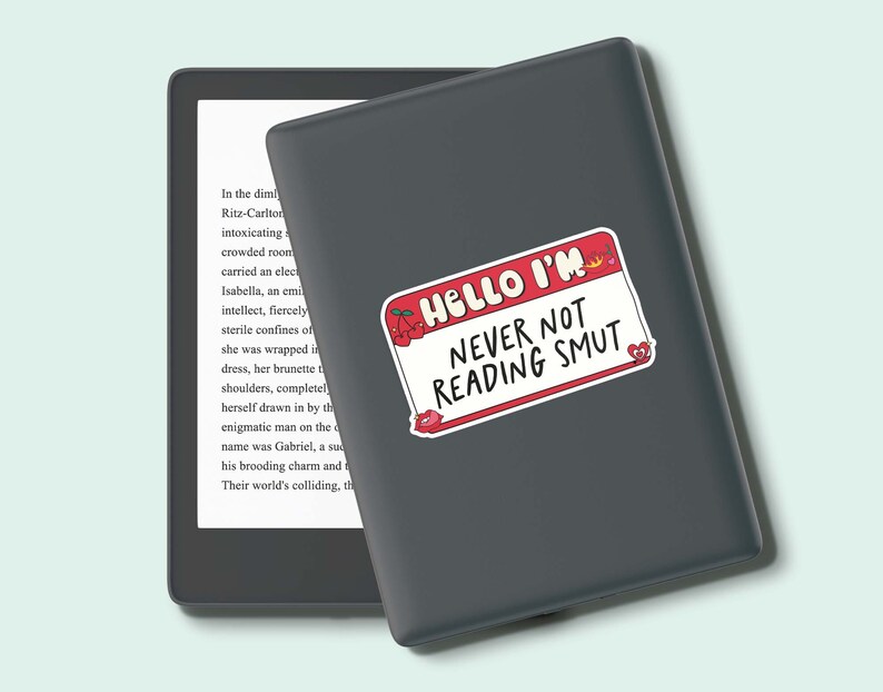 May include: A gray Kindle e-reader with a red and white sticker that says "Hello I'm Never Not Reading Smut".