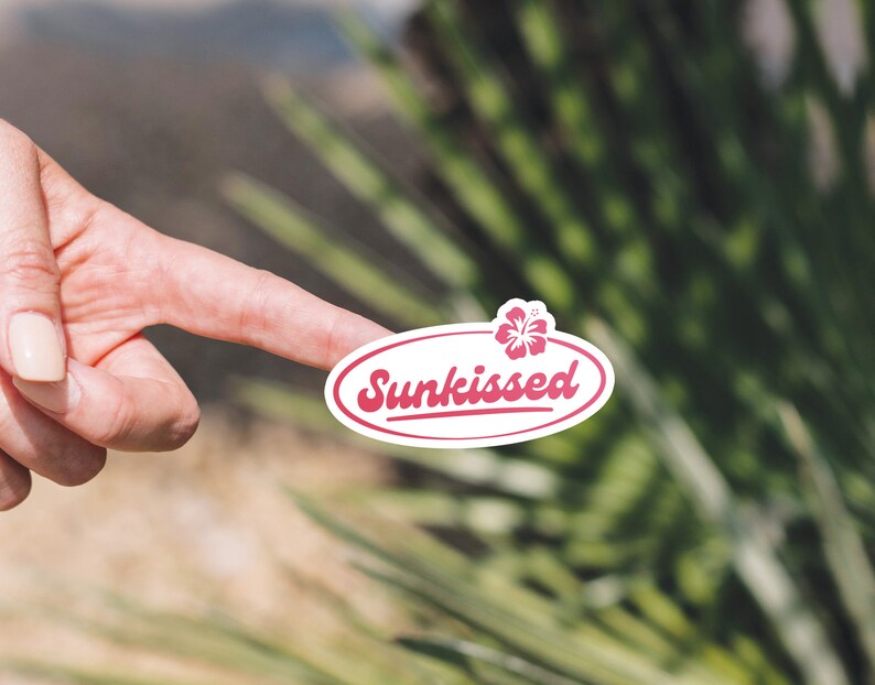 May include: White oval sticker with a pink hibiscus flower and the text "Sunkissed" in a pink cursive font.
