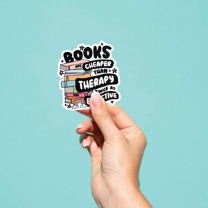 May include: A sticker with a stack of colorful books and the text "BOOKS ARE CHEAPER THAN THERAPY AND TWICE AS EFFECTIVE".