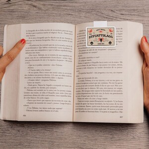 Puede incluir: Primer plano de un libro con un marcap&aacute;ginas que presenta una ouija blanca y marr&oacute;n con el texto "STFUATTDLAGG" y "GOOD BYE".