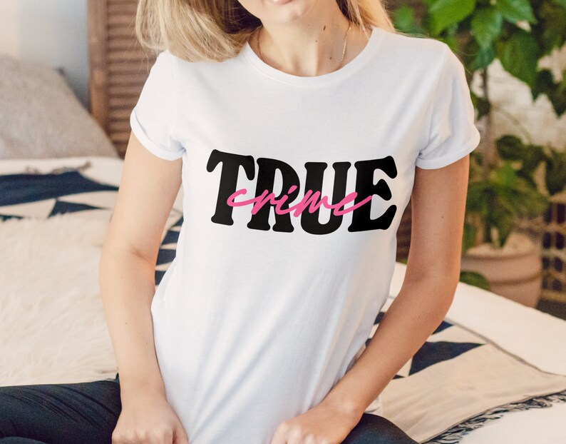 May include: White t-shirt with black text that says "TRUE crime" in a retro font. The word "crime" is in pink.