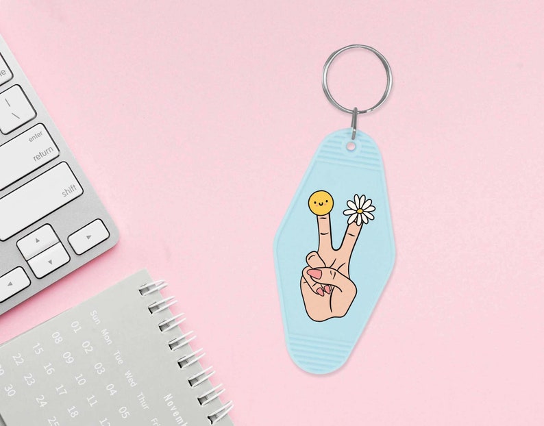 May include: A light blue motel key chain with a peace sign, a daisy, and a smiley face on it.
