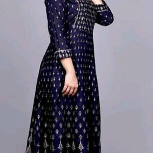 May include: A long, navy blue dress with a silver and white geometric pattern. The dress has a round neckline and three-quarter sleeves.