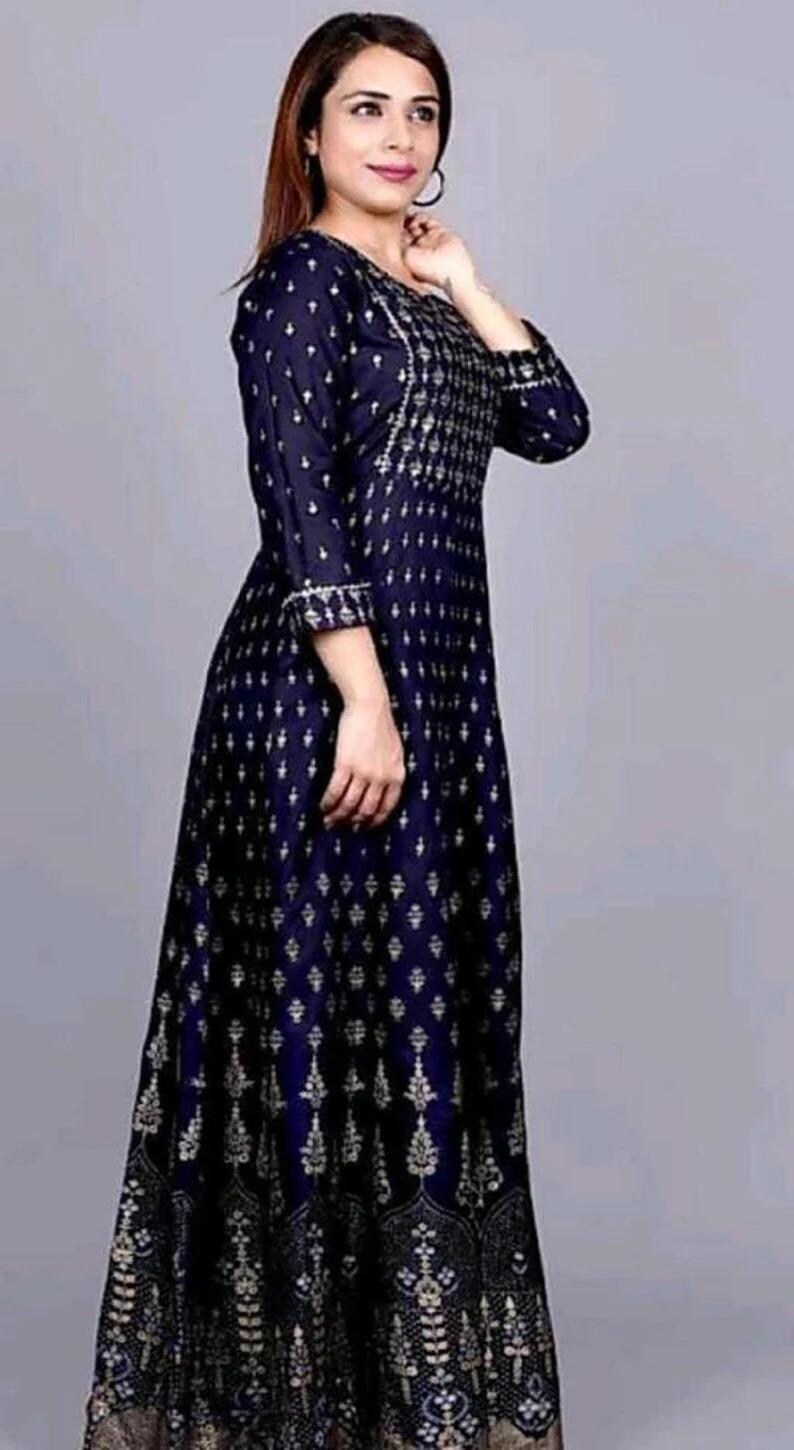 May include: A long, navy blue dress with a silver and white geometric pattern. The dress has a round neckline and three-quarter sleeves.