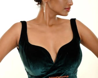 Pode incluir: Um top curto de veludo verde escuro com um decote em V profundo e um design cruzado na frente. O top é feito de um tecido macio e luxuoso e tem uma silhueta ajustada. O texto "TrishFashionHub" é visível na parte inferior do top.
