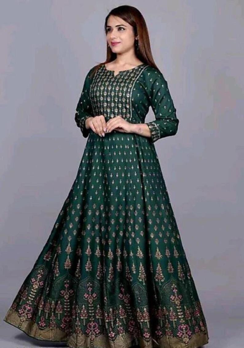 May include: A long, green maxi dress with a gold floral print. The dress has a V-neckline and three-quarter sleeves.
