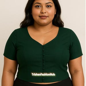 Könnte beinhalten: Dunkelgrünes, kurzärmeliges Oberteil mit V-Ausschnitt und einer Reihe kleiner Knöpfe vorne. Das Oberteil ist gecroppt und trägt den Text "TrishanFashionHub".