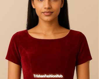 May include: A burgundy velvet crop top with short sleeves and a scoop neckline. The text "TrishanFashionHub" is displayed on the front. The top is worn by a person with long black hair.