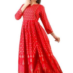 May include: A red maxi dress with a gold print. The dress has a V-neckline and 3/4 sleeves. The dress is made of a soft, comfortable fabric and is perfect for any occasion.
