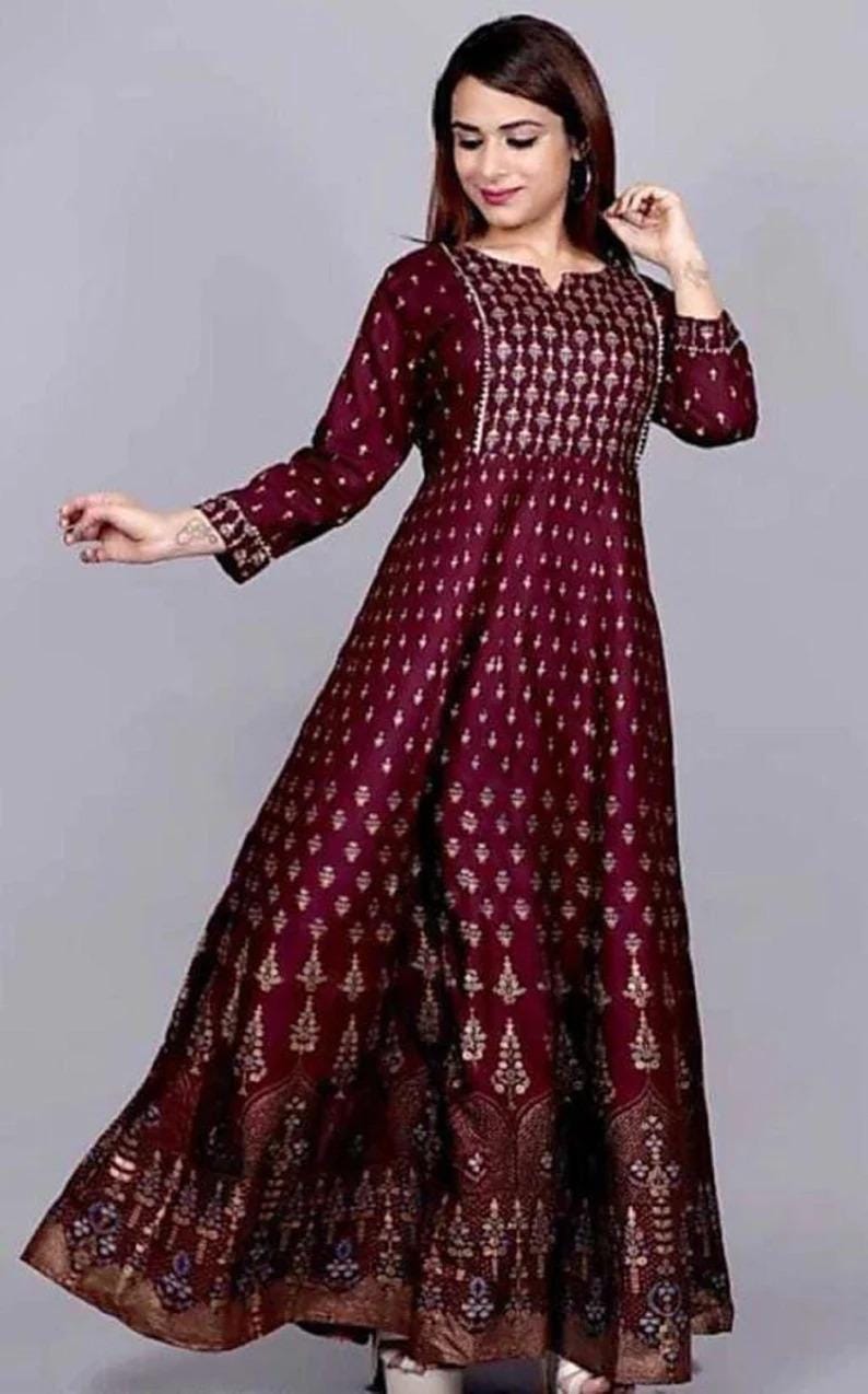May include: A maroon maxi dress with a gold print. The dress has a V-neckline and three-quarter sleeves.