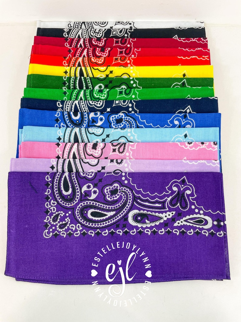 Puede incluir: Una pila de doce pa&ntilde;uelos cuadrados en varios colores, incluyendo blanco, negro, rojo, amarillo, verde, azul marino, azul, azul claro, rosa, lavanda y morado. Cada pa&ntilde;uelo presenta un patr&oacute;n de cachemira blanco tradicional y un logotipo central que dice ESTELLEJOYLYNN ejl.