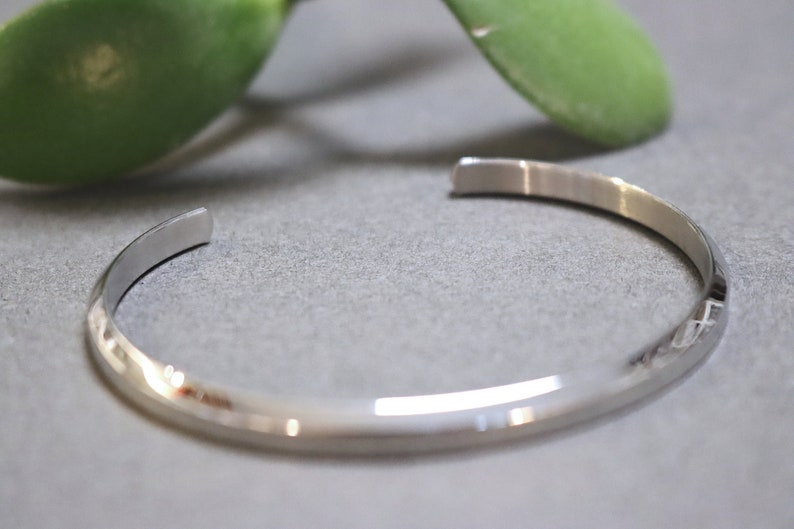 May include: A silver bangle bracelet with a smooth, polished finish.