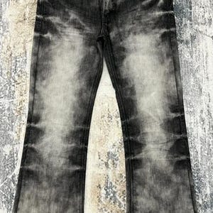 Op de afbeelding: Zwarte denim jeans met een vervaagde, verweerde look. De jeans hebben een bootcut-stijl en zijn gemaakt van een zachte, comfortabele stof.