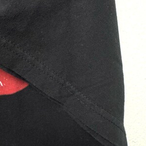 Puede incluir: Primer plano de la costura de tela negra de una camiseta negra. La costura est&aacute; cosida con una puntada recta.