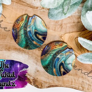 May include: Two round car coasters with a swirling design in shades of teal, blue, gold, and purple. The coasters are on a wooden surface, with a logo that says "The Wicked Trendz".