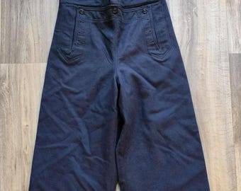 May include: Navy blue wide-leg pants with a high waist and button details. The pants feature two front pockets and a button fly. The fabric appears to be a medium-weight material.