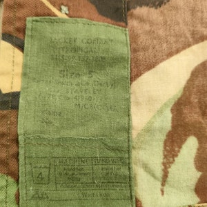 May include: A green fabric label with the text "M.S.E.F. COMBAT", "U.S. ARMY ISSUE", "SIZE 2", "D.I.Y.", "MACHINE WASHABLE", "HAND WASH", "Tumble Dry", "Do Not Bleach", "Iron Low", "Do Not Dry Clean", and "SIZE 2" printed on it.