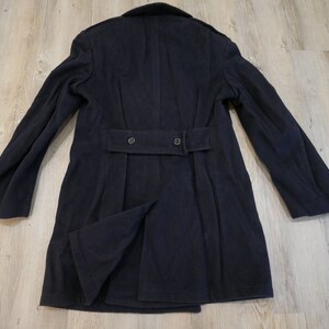 May include: A dark blue wool peacoat with a belt and two buttons on the back.