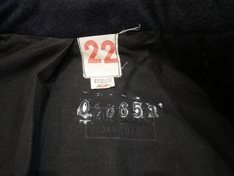 May include: A black fabric label with white text that reads "22" and "MITIN ANTINITIF" and a black stamp with the number "046651".