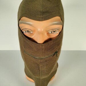 Peut inclure: Une cagoule brune avec une fermeture éclair sur le devant. La cagoule est faite d'un tissu doux et tricoté.