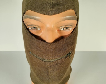 May include: A brown balaclava with a zipper on the front. The balaclava is made of a soft, knitted fabric.