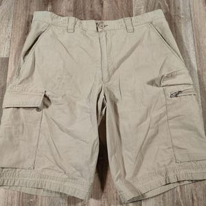Könnte beinhalten: Beige Cargo-Shorts mit mehreren Taschen und einer Reißverschlusstasche auf der rechten Seite.