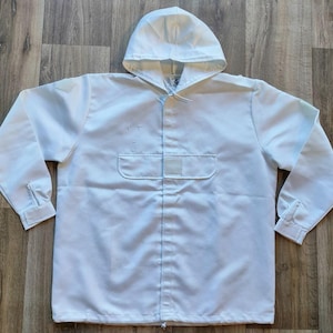 May include: A white hooded jacket with a zipper closure and a patch pocket on the front.